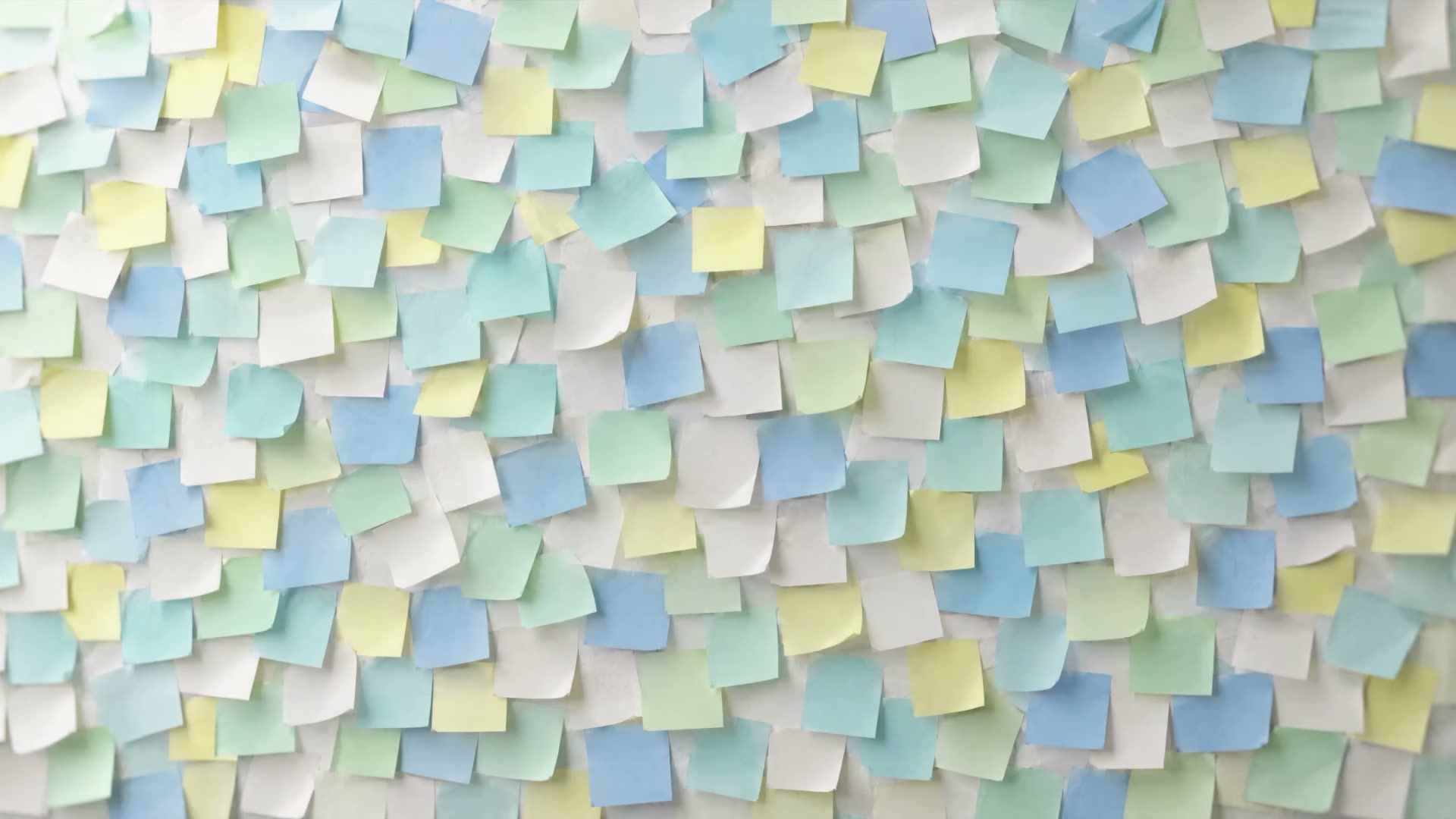 A wall covered edge to edge in blank pastel sticky notes